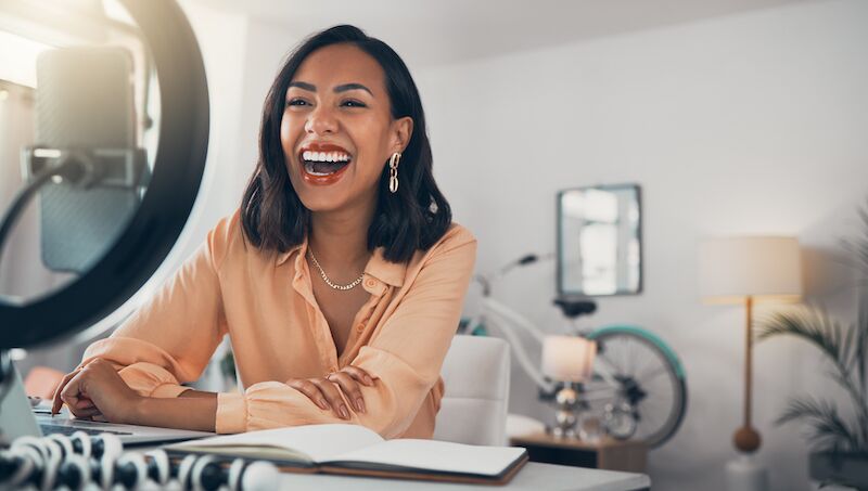 Femme souriante devant un micro, illustrant l’enthousiasme et la générosité nécessaires pour devenir conseiller en image - Première Impression