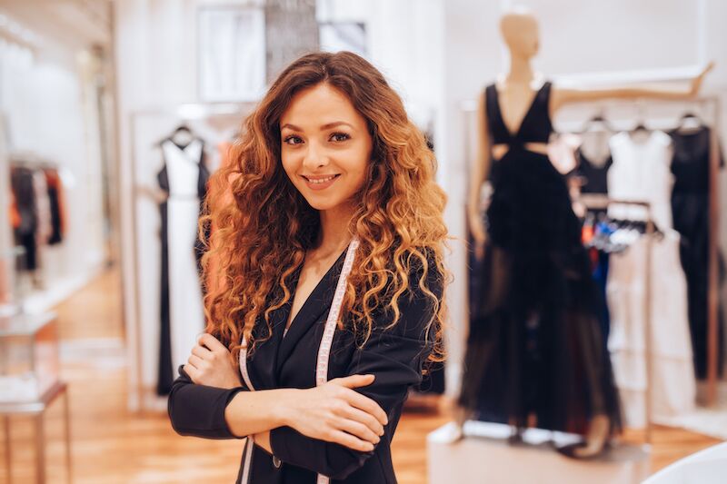 Conseillère en image confiante dans une boutique, illustrant l’expérience acquise dans le métier de conseiller en image - Première Impression
